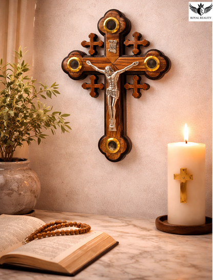 Wooden cross with Jesus figure, candle, and open book on a table.